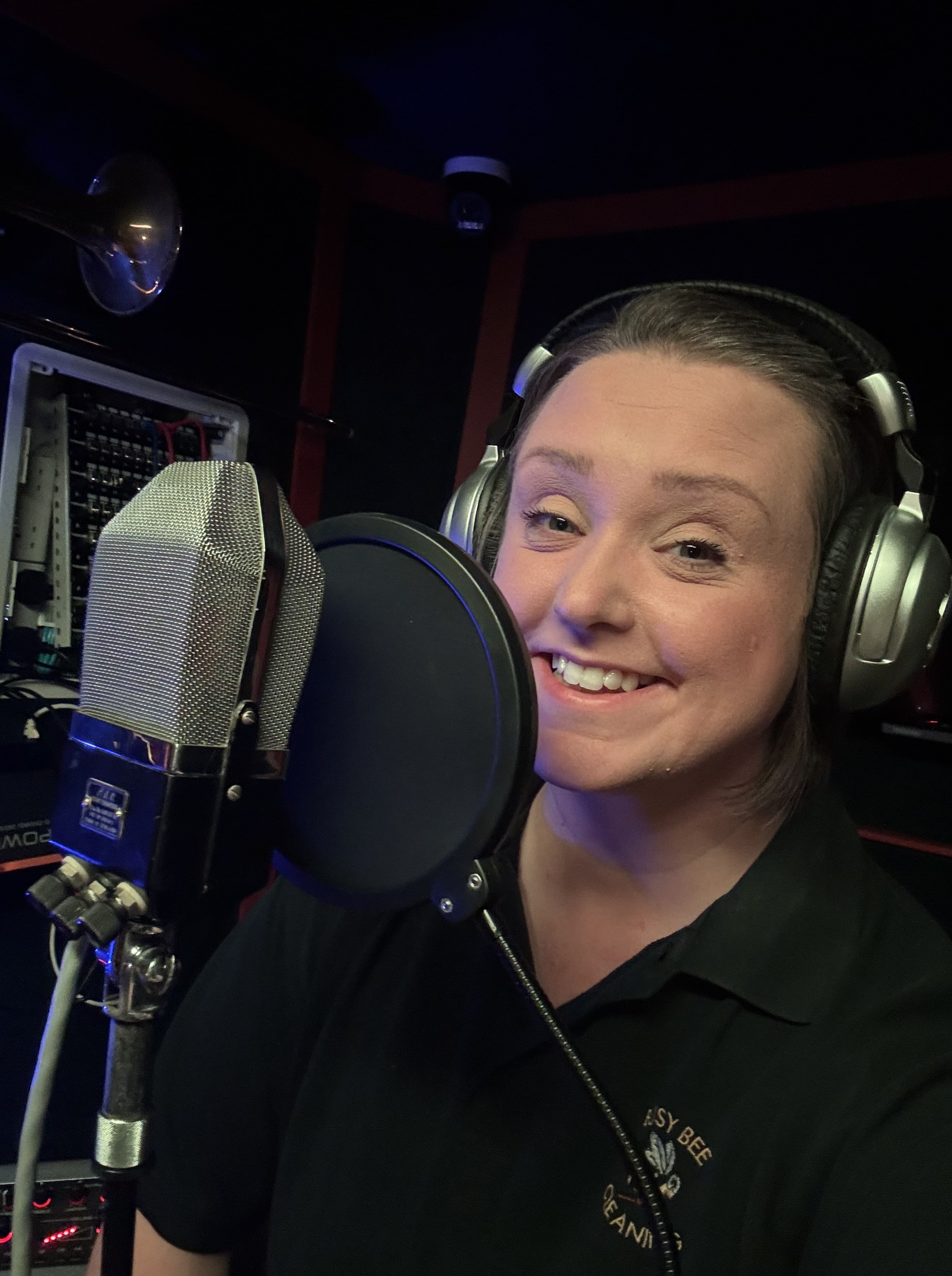 A vocalist recording at the microphone at 4chordsStudios