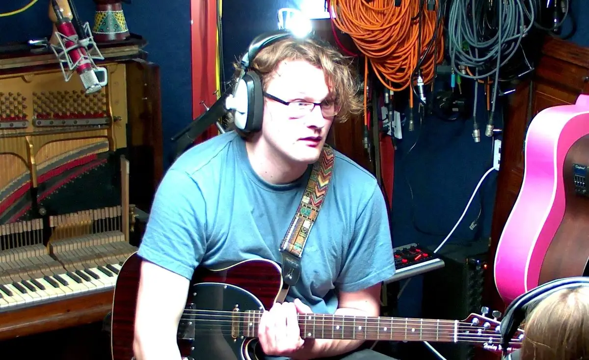 Asher Walker tracking guitar in the live room at 4chordsStudios