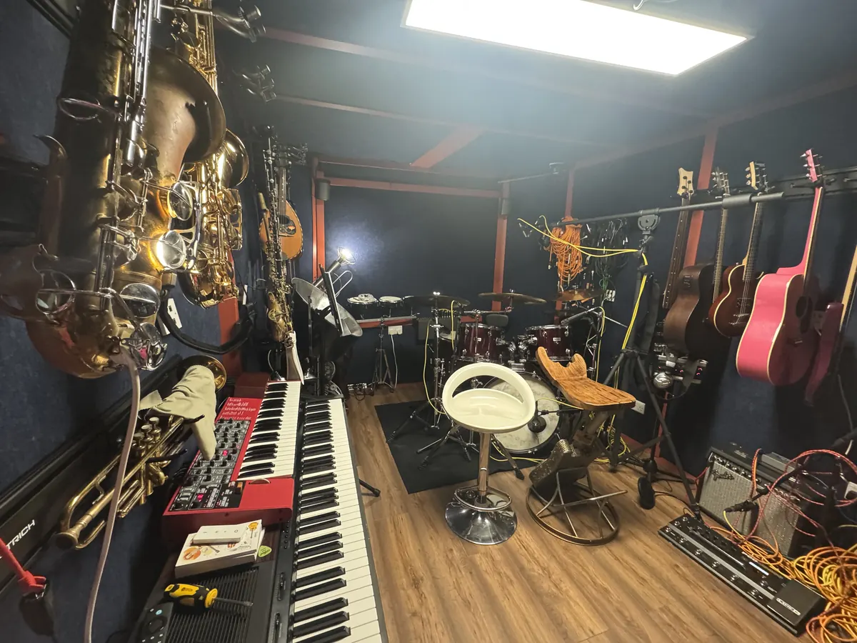 Saxophones, a trumpet and stage keys in the 4chordsStudios live room, with the drum kit behind